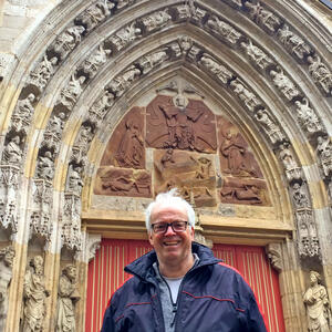 Bild vergrößern: Dr. Hartmut Wolf steht vor seinem Liblingsplatz, dem Südportal der Korbacher Kilianskirche.