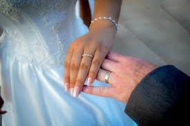 Bild vergrößern: Das Bild zeigt die Hände eines Brautpaares mit Eheringen.