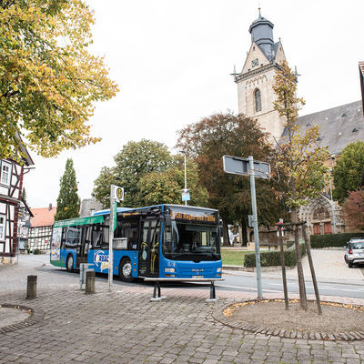 Bild vergrößern: Das Bild zeigt einen Stadtbus und die Korbacher Kilianskirche.