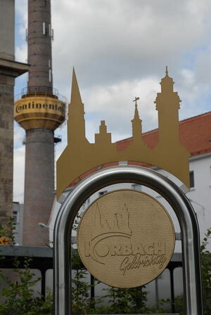 Bild vergrößern: Abbilldung eines Korbacher Goldtalers mit Conti-Turm im Hintergrund